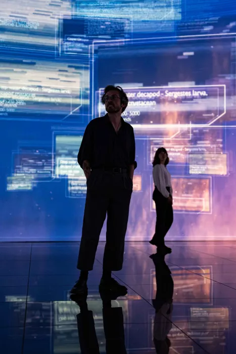 Two people visiting immersive exhibition lights