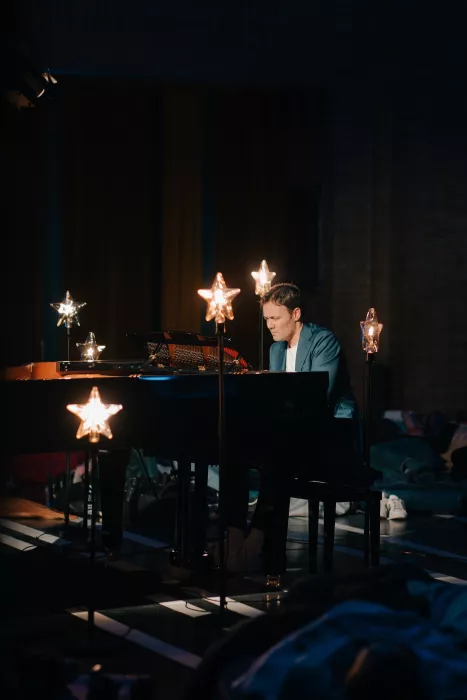 Pianist in darm room with start lights